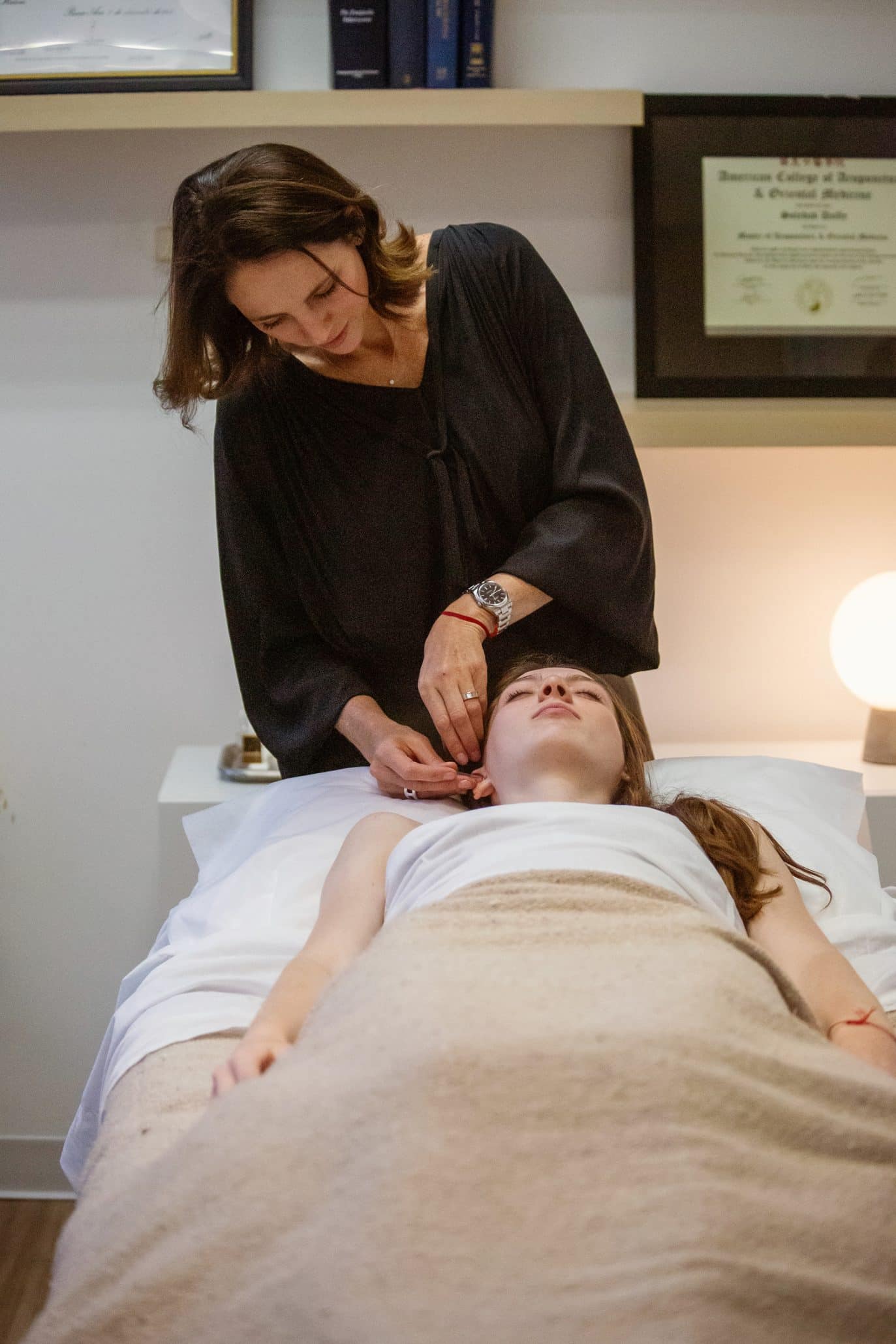 Woman giving acupuncture treatment in a clinic.