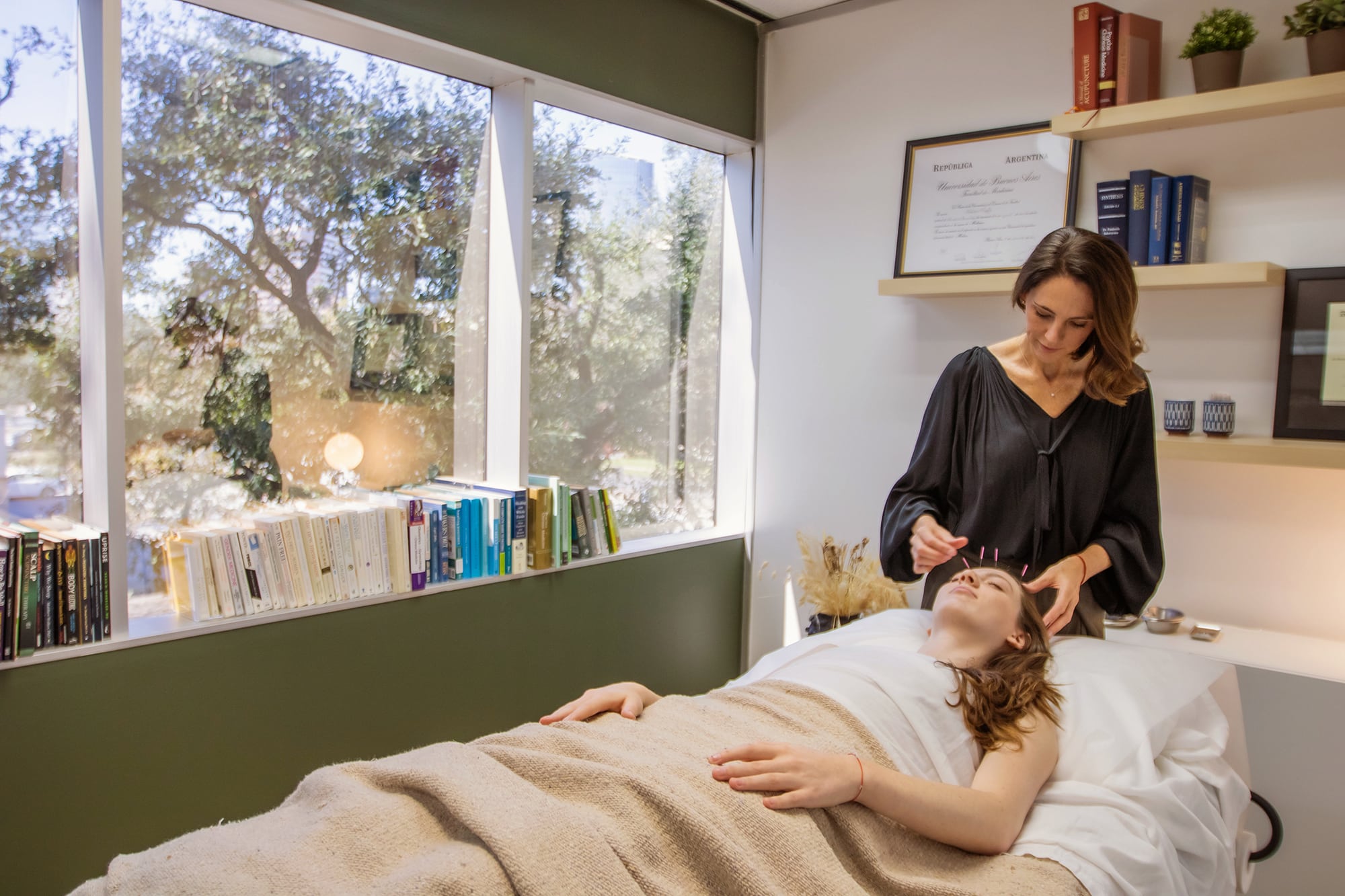 Woman receiving acupuncture treatment in professional office.