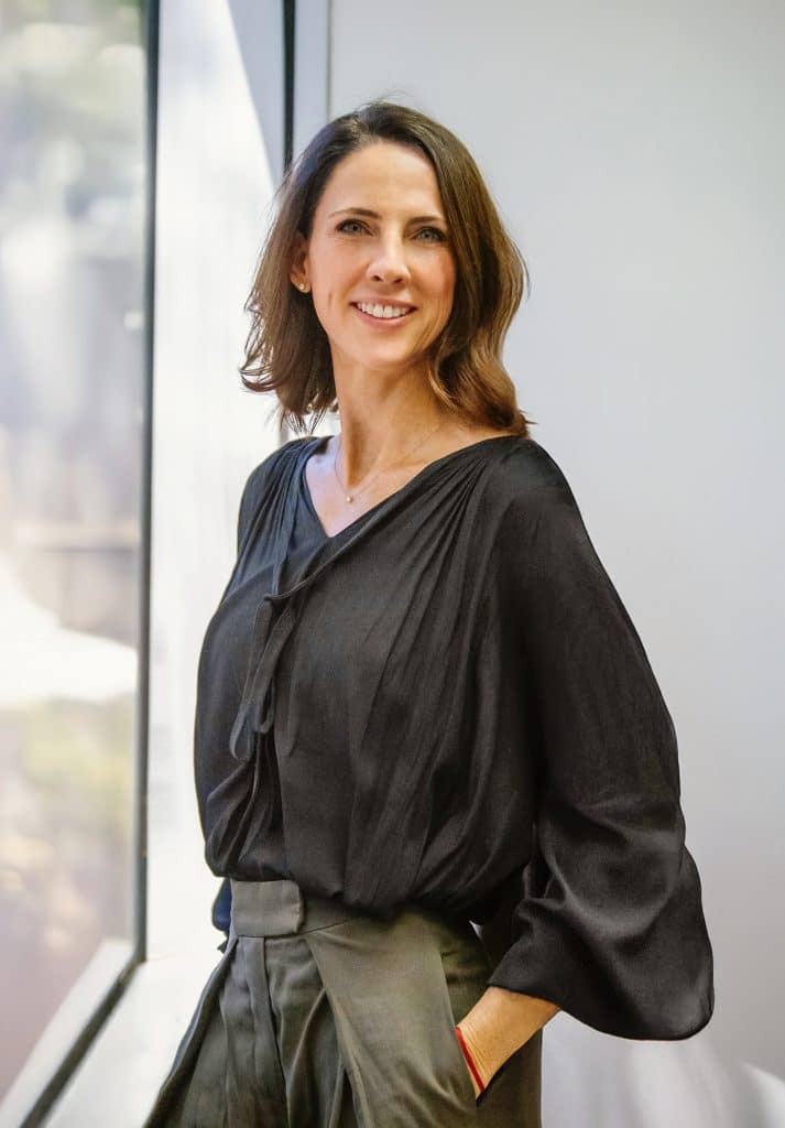 Smiling woman in black blouse by window