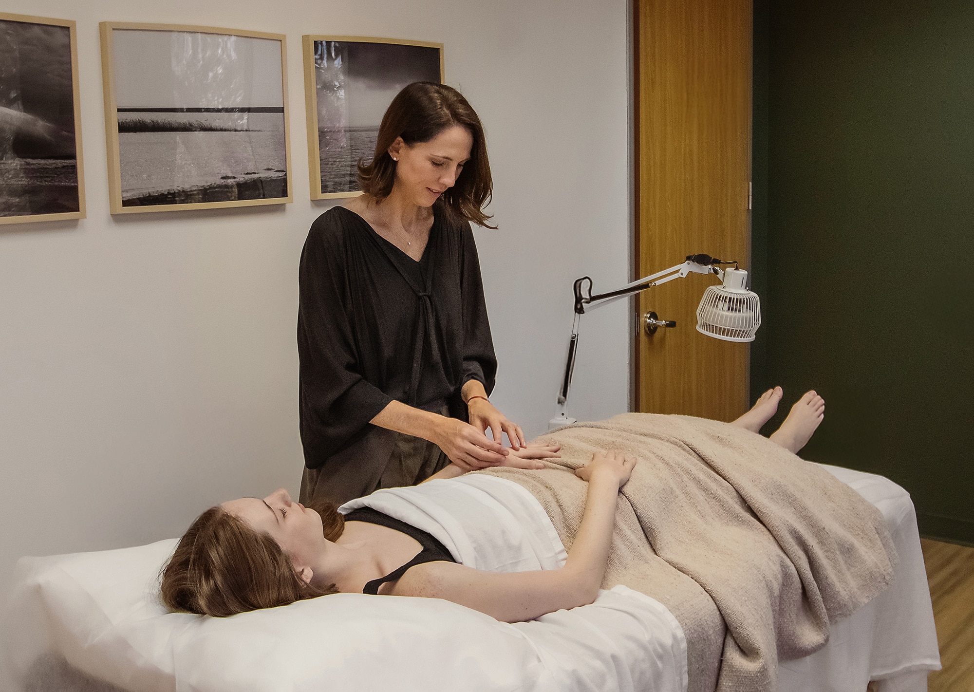 Therapist providing acupuncture treatment on patient's hand.